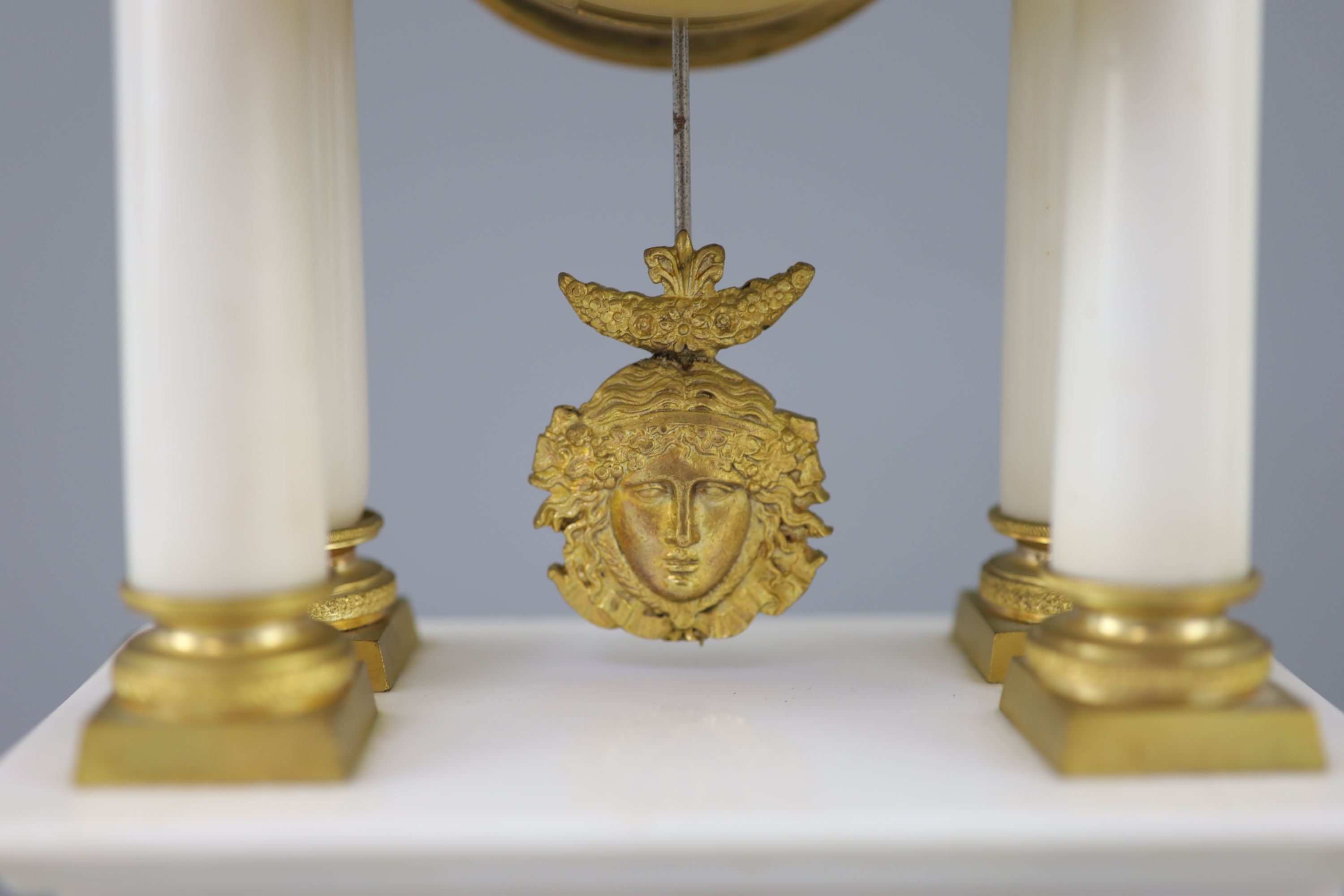 A Louis XVI style ormolu mounted white marble clock garniture, clock 14.5in. urns 13.75in.